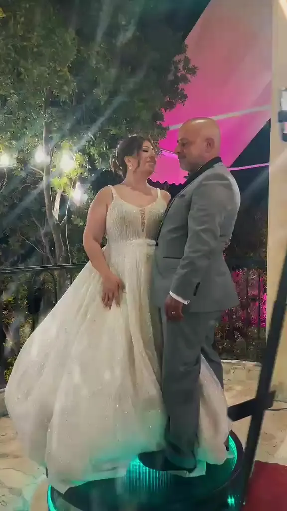 A bride and groom standing together on the 360 cam platform
