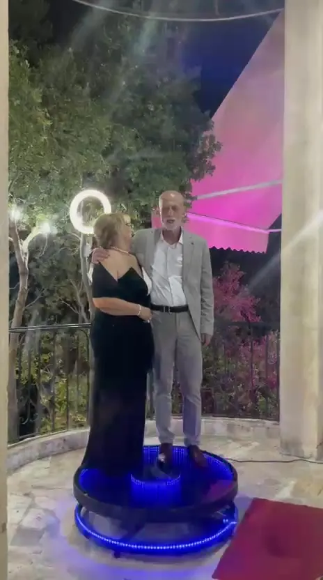 A couple on the 360 cam platform lit purple against the evening trees