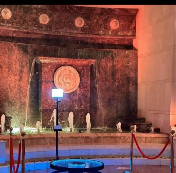 A 360 cam platform set up on a red carpet inside a lit venue