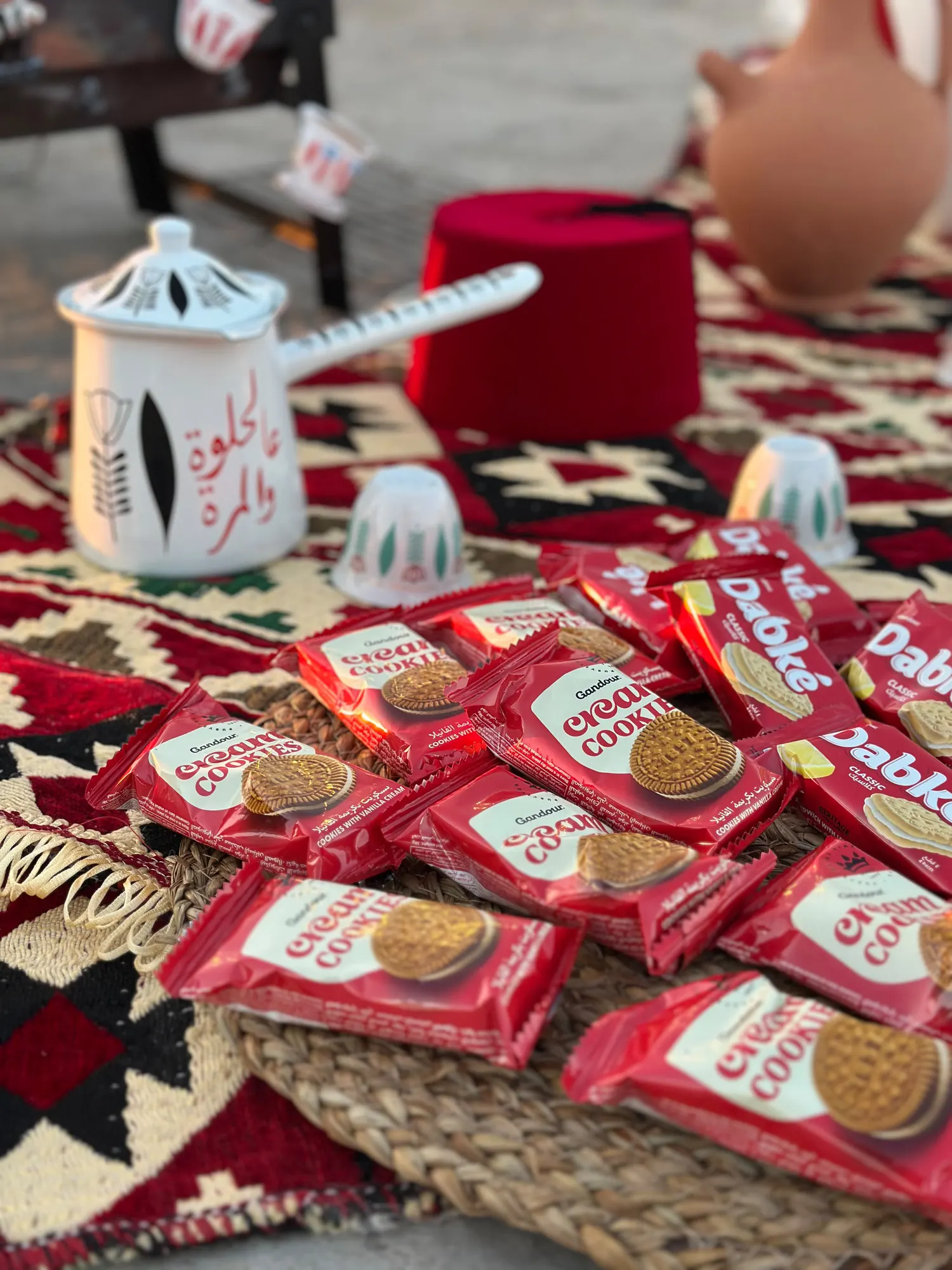 An Arabic coffee pot and wrapped biscuits laid out on a woven kilim
