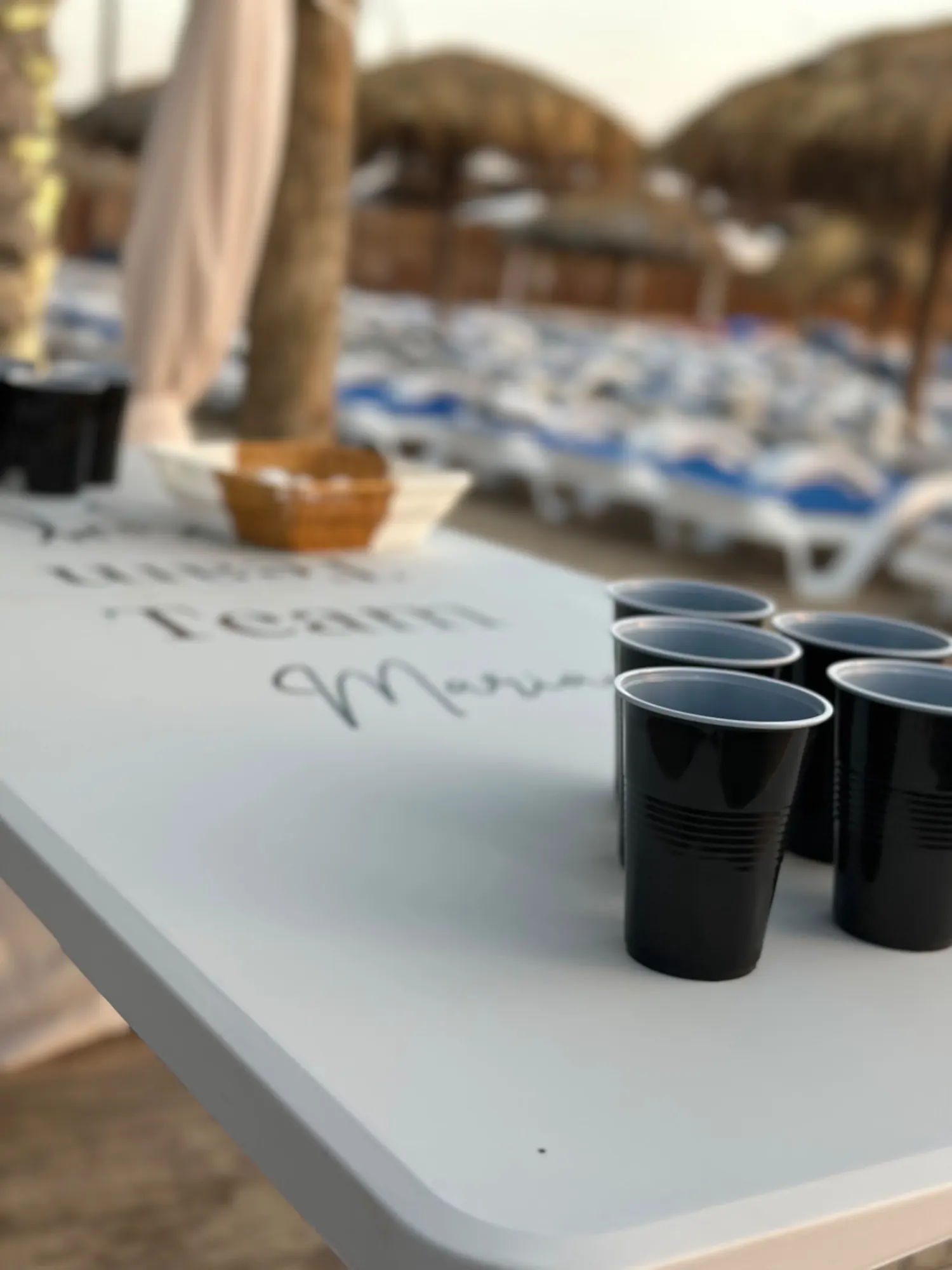 A beer pong table set up beside the sea at golden hour