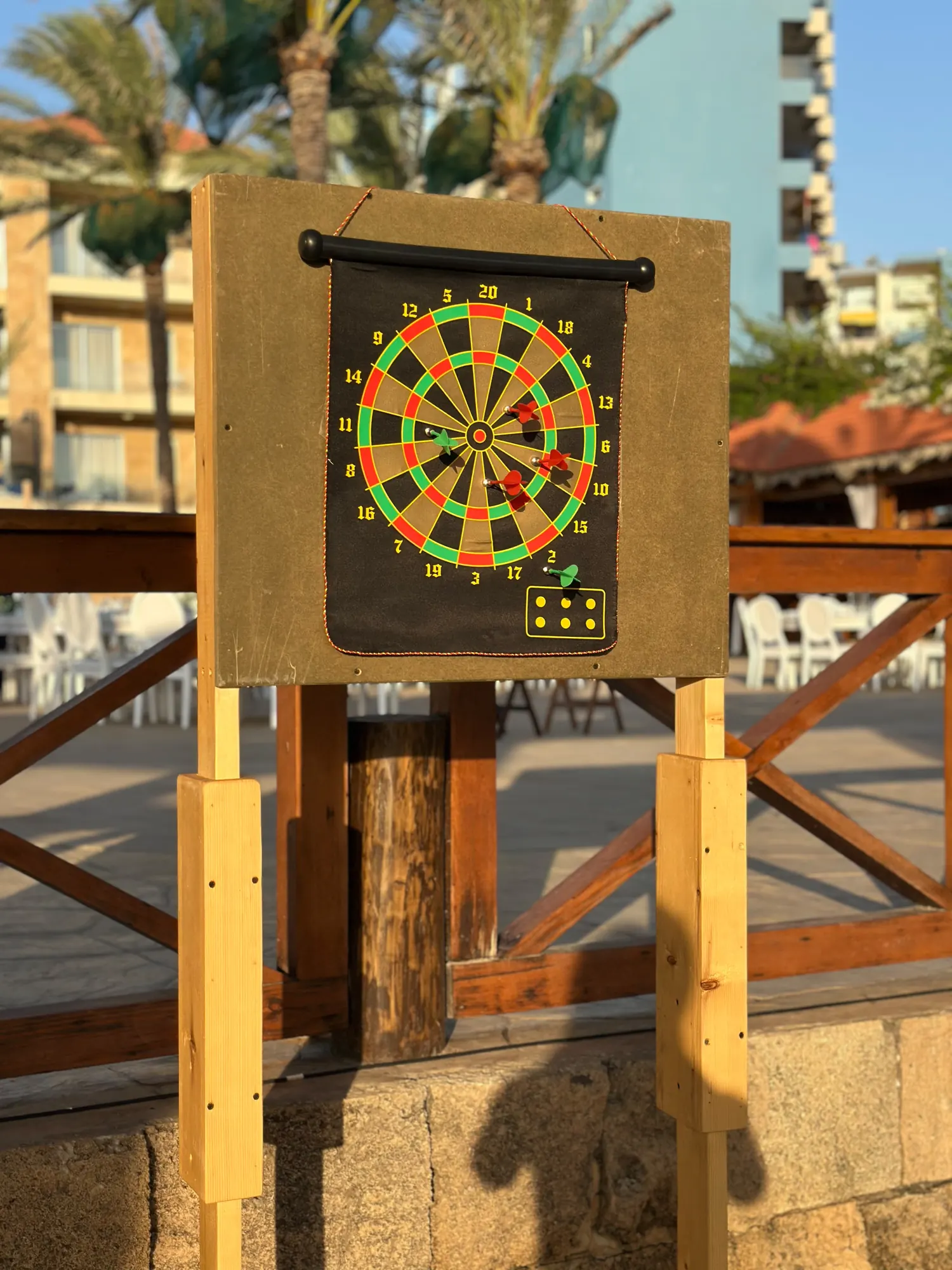 A darts board mounted on a wooden stand at a seaside event