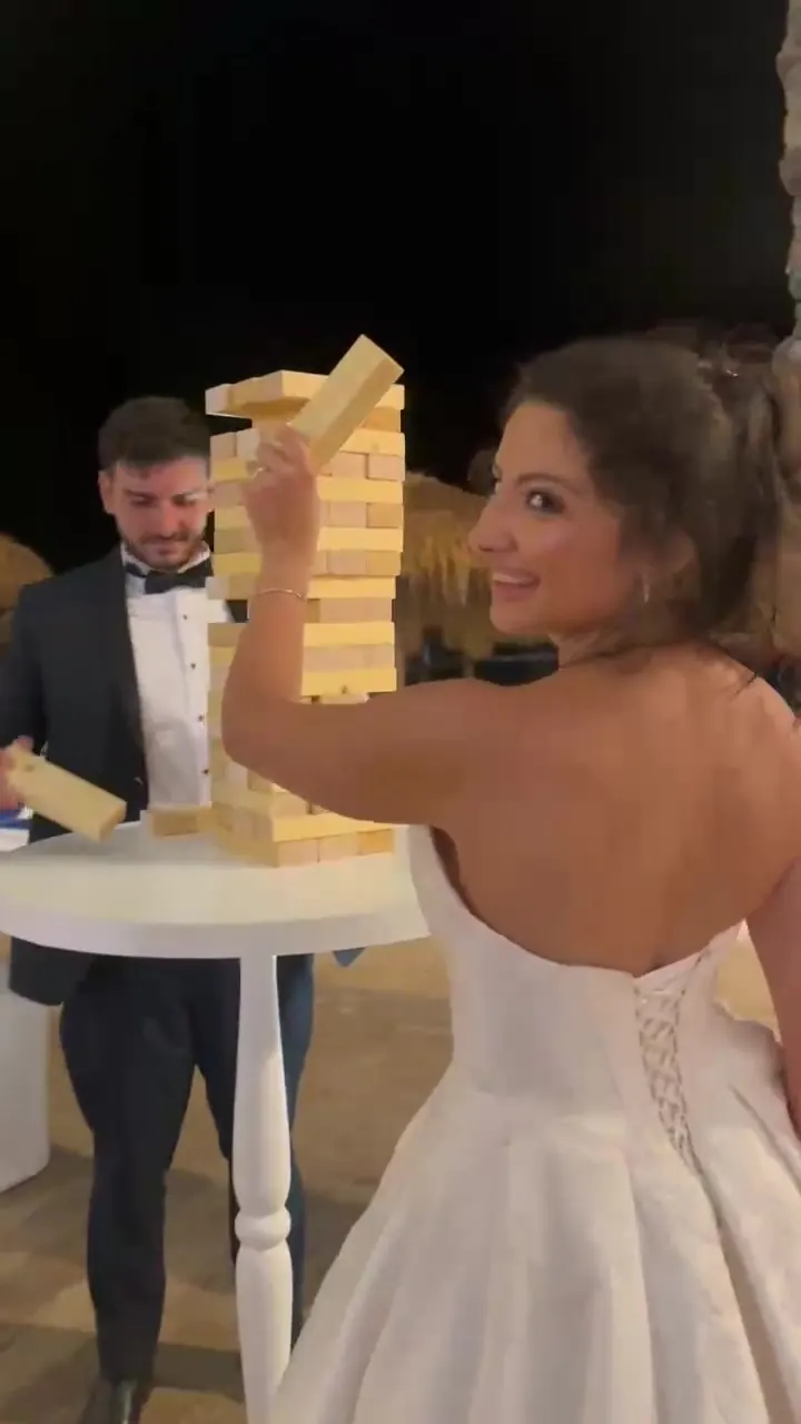 A bride and groom playing giant Jenga at their reception