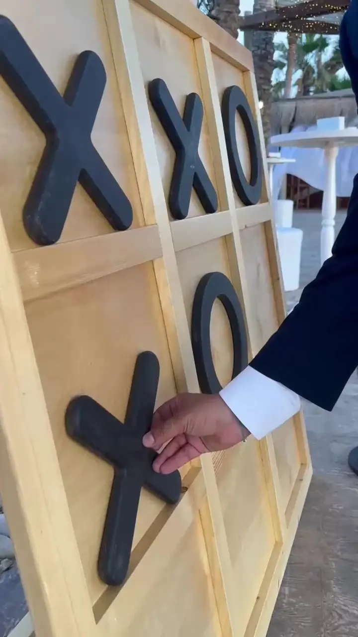 A guest placing a piece on a giant XO board