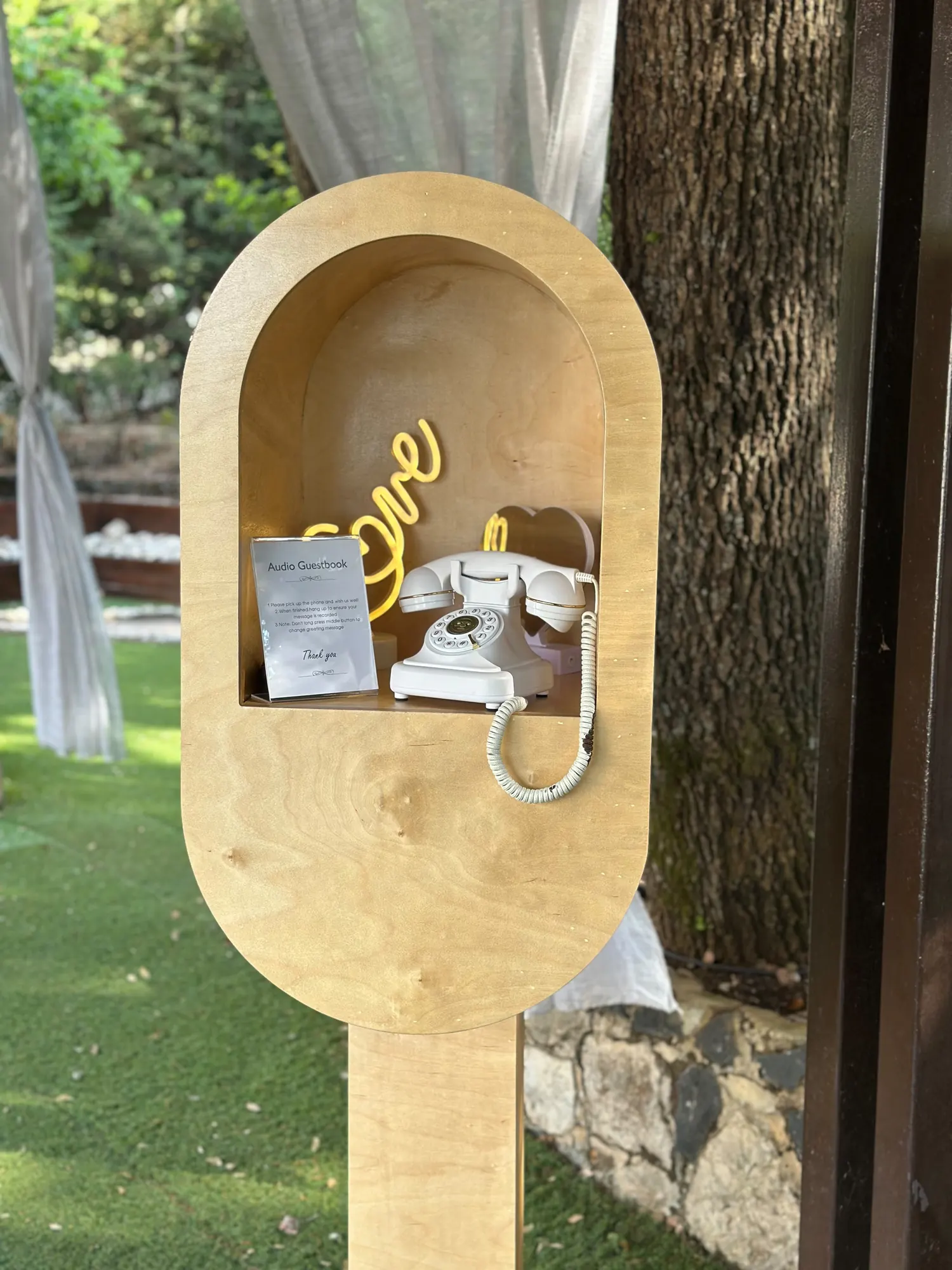 The Leave a Message booth beside a draped white curtain