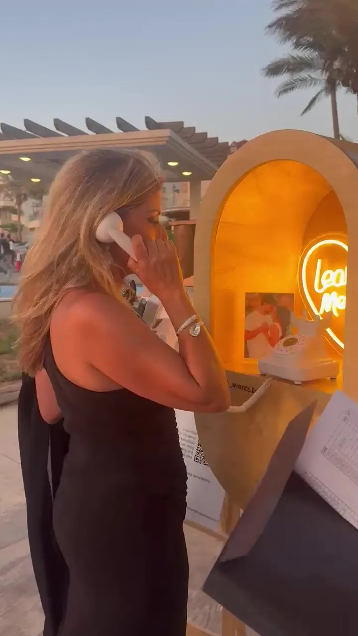 A guest standing at the Leave a Message booth holding a drink