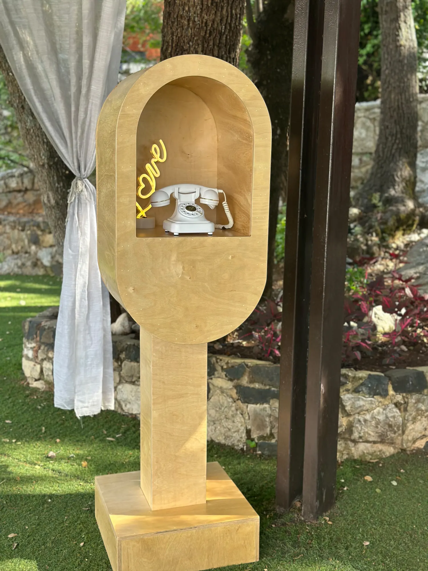 The full Leave a Message booth standing on a lawn beside a white curtain